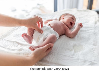 Newborn baby screaming while mother puts a diaper on the changing table - Powered by Shutterstock