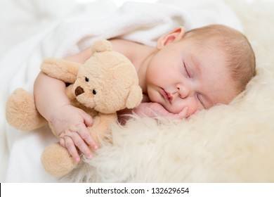 newborn baby sleeping on fur bed