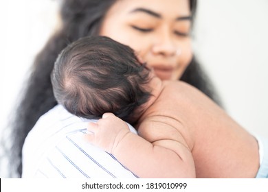 Newborn Baby Sleeping On Mother Shoulder. African American Mom Comforting Her Baby At Home