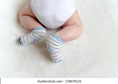 newborn baby sleeping on white. rear view. butt in a diaper, with a adorable crossed legs and feet