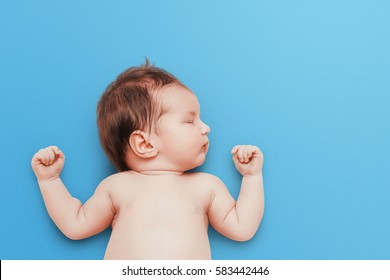 Newborn Baby Sleeps On Blue Background. Child's Portrait.