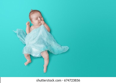 Newborn Baby Sleeps On Blue Background.