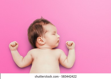 Newborn Baby Sleeps On Pink Background. Child's Portrait.