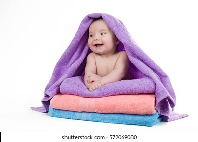 Newborn Baby Smiling Lying On A Stack Of Towels