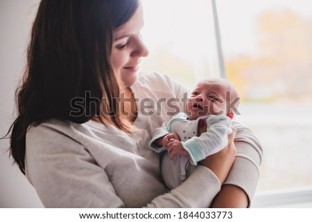 Similar – Image, Stock Photo Mother hugging her baby in front of fireplace