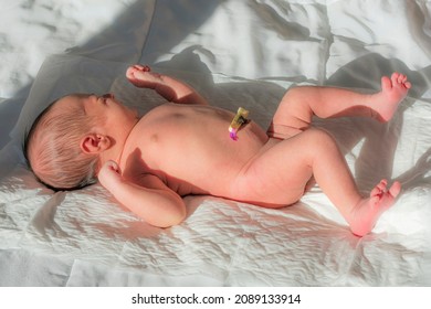 Newborn Baby Where The Umbilical Cord Clamp Is Seen Cries Lying On A Soaker