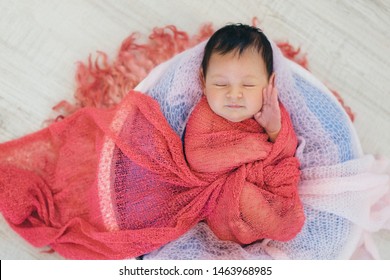 Newborn Baby Wrapped In A Blanket Sleeping In A Basket. Concept Of Childhood, Healthcare, IVF
