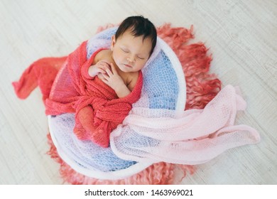 Newborn Baby Wrapped In A Blanket Sleeping In A Basket. Concept Of Childhood, Healthcare, IVF