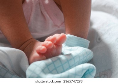Newborn baby's feet are still very small. The baby's feet are held by the mother with great affection - Powered by Shutterstock