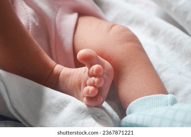 Newborn baby's feet are still very small. The baby's feet are held by the mother with great affection - Powered by Shutterstock