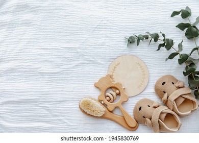Neugeborene Schuhe mit leerer Karte und Holzspielzeug. Babyhintergrund, Draufsicht, flacher Hintergrund, Kopienraum 