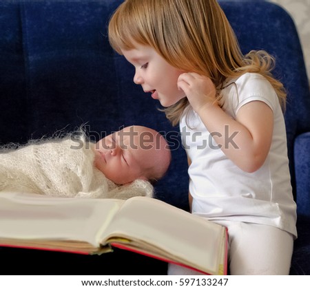 Similar – Mother reading book to her sons in the bed