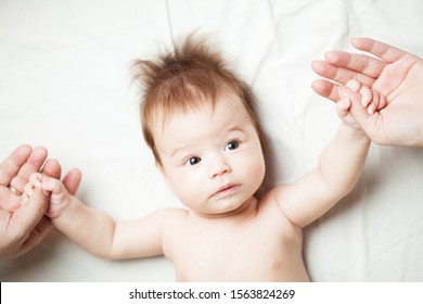 Newborn Caucasian Baby Lying On Bed, Holding Mom And Dad's Hands, Family And Togetherness Concept, Overhead Flat Lay Top Down View 