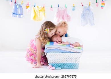 Newborn Child On A Pile Of Clean Dry Towels. Brother And Sister Kissing Little Sibling. Siblings Bonding. Twin Toddler Kids Kiss Baby Boy. New Born Kid After Bath In A Towel. Family Washing Clothes. 