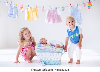 Newborn Child On A Pile Of Clean Dry Towels. Brother And Sister Kissing Little Sibling. Siblings Bonding. Twin Toddler Kids Kiss Baby Boy. New Born Kid After Bath In A Towel. Family Washing Clothes. 