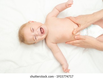 Newborn Is Crying Because Of Colic Pain. Massage Stomach For Little Newborn Baby. Mom Massaging Colic Tummy Of Newborn