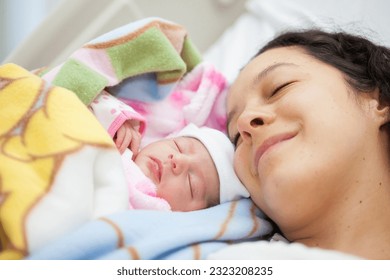 Newborn girl with her mom in the hospital on the day of her birth. Motherhood concept - Powered by Shutterstock