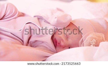 newborn happy baby a girl sleeping. happy family baby dream concept. newborn girl in a hat and suit sleeping in the maternity lifestyle hospital waiting for discharge. cute beautiful baby sleeping