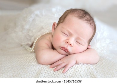Newborn with head resting on arms