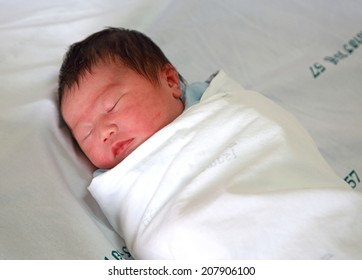 Newborn Infant Asleep In The Blanket In Delivery Room