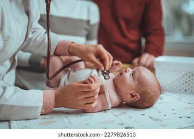 Newborn lying on back while doctor listening to his heartbeat with stethoscope at hospital. Close up of unrecognizable doctor examining cute baby lying on changing table in clinic, copy space - Shutterstock ID 2279826513