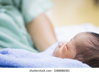 The newborn is lying on the mother lap. - Shutterstock ID 1088888381