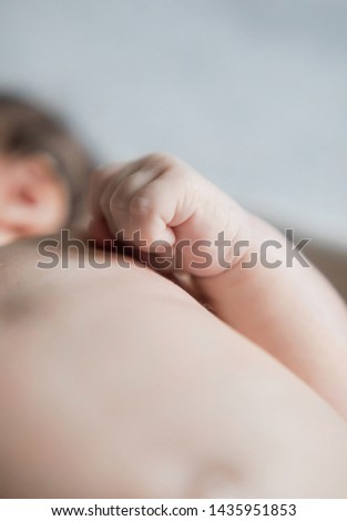 The newborn is lying, the small hand is clenched into a fist. New life. Children and pregnancy. Baby and parents. Happy dad and mom. The continuation of the human race.