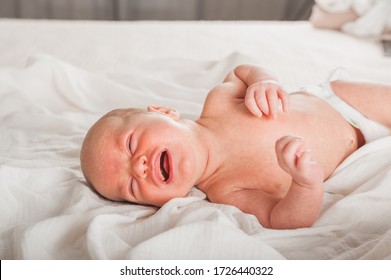 Newborn On The Bed. Crying, Screaming Baby Close Up And Copy Space. Baby Smile And Colic In Newborns. Seborrheic Dermatitis In Newborns