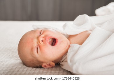 Newborn On The Bed. Crying, Screaming Baby Close Up And Copy Space. Baby Smile And Colic In Newborns. Seborrheic Dermatitis In Newborns