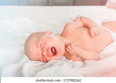 Newborn On The Bed. Crying, Screaming Baby Close Up And Copy Space. Baby Smile And Colic In Newborns. Seborrheic Dermatitis In Newborns