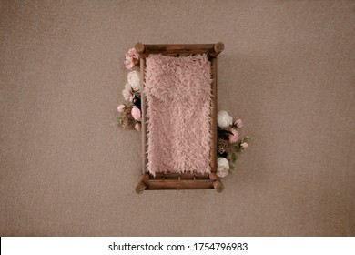 Newborn photography digital background - wooden bed with pink fur and floral arrangement. Newborn girl photography backdrop.