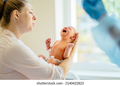 Newborn physical exam. First moments of bonding. Mother caressing and calming down her crying newborn baby daughter in hospital. - Shutterstock ID 2140422823