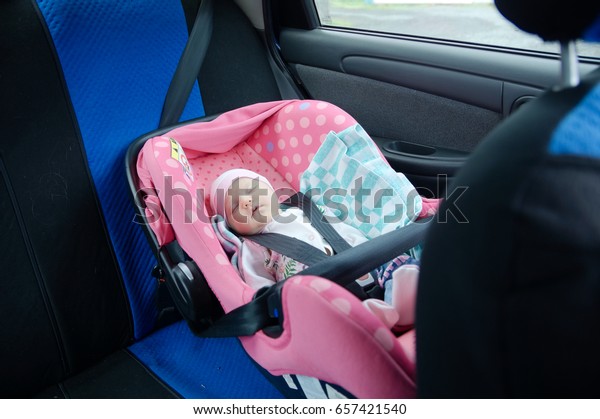 Newborn sleeping in car seat.Safety concept. Infant\
baby girl. secure driving with children. Baby care lifestyle. Cute\
baby sleeping in car.