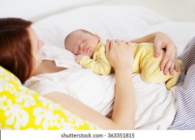 Newborn Sleeping Child In The Hands Of Mother