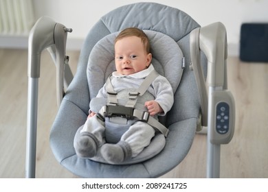 Newborn Swing Baby Swing Automatic Electric Chair. Cute Smiling Baby Laying In Bouncer Chair. Child Relaxing In A Swing. Family Morning At Home.