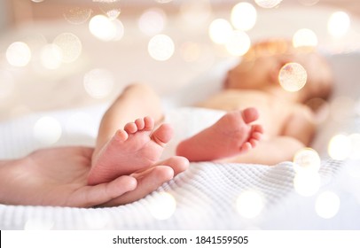 Newborn tiny legs. Sister holding little feet. Two people. Healthcare concept. Unrecognised modern parenthood. Comfort and safety sleep. Human insurance. Family miracle. No face