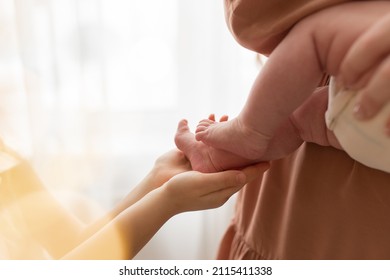 Newborn Tiny Legs. Sister Holding Little Feet. Two People. Healthcare Concept. Unrecognised Modern Parenthood. Comfort And Safety Sleep. Human Insurance. Family Miracle. No Face