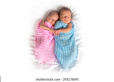 Newborn twins sleeping in cuddle together