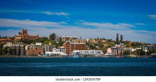 Newcastle Australia CBD With Hunter River In The Foreground On Sunny Day With Blue Sky Background.