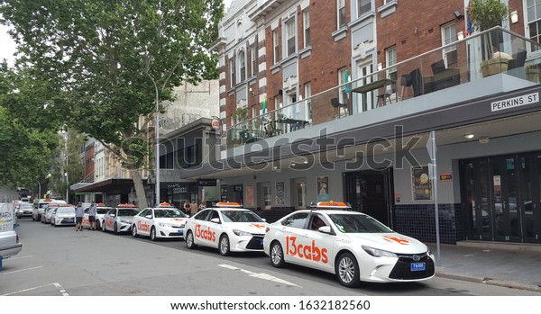 Newcastle, Australia - Nov 2019: View of taxi by\
13 cabs parking by the street waiting for passenger during supercar\
event held in december.  It is Australia\'s leading taxi company\
with online booking