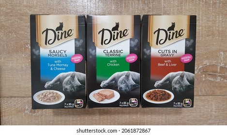 Newcastle, Australia - Oct 2021: View Of Variety Flavour Boxes Of Dine Daily Slices Trays Wet Cat Food In Wooden Background. Box Of Wet Cat Food Formula Combines Finely Sliced Pieces Of Real Meat 