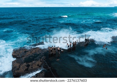 NEWCASTLE, NEW SOUTH WALES, AUSTRALIA. People are playing at Bogey Hole in Newcastle, one of Australia's oldest ocean baths.