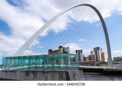 Newcastle, UK - 7 May 2019: Gateshead Millennium Bridge Is A Pedestrian And Cyclist Tilt Bridge Spanning The River Tyne. Baltic Flour Mills Derelict Building In The Background. City Scape, Skyline.