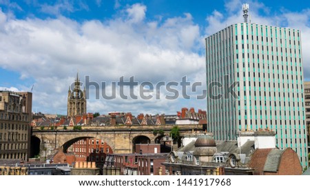 Newcastle Upon Tyne City Skyline showing a tower block to the right with various buildings, the spire of St Nicholas Cathedral and high level train bridge cutting through it. 
