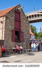 Newcastle Upon Tyne, UK - May 28th, 2022: The Traditional Pub Exterior And People Drinking Outside Of The Wetherspoons Quayside Bar On A Sunny Day. 