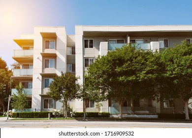 Newer multi family apartment building with trees in a Suburban setting - Sunny Day - Real Estate - Shutterstock ID 1716909532