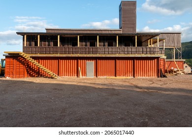 Newfoundland, Canada-October 2021: The Exterior Construction Of A Hotel Using Shipping Containers As Modular Construction. Recycled Brown And Orange Metal Ocean Sea Cans Stacked To Build A New House.