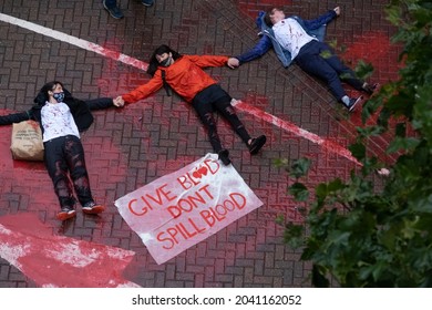 Newham, LONDON - 14 September 2021 - Protesters close to Excel Centre oppose UK hosting of arms fair "DSEI" by posing as corpses in a pool of blood