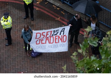 Newham, LONDON - 14 September 2021 - Protesters nearby to Excel Centre hold up a banner against UK hosting of arms fair DSEI