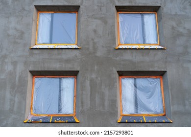 A newly built building in a closed shell with inserted windows secured with a protective foil